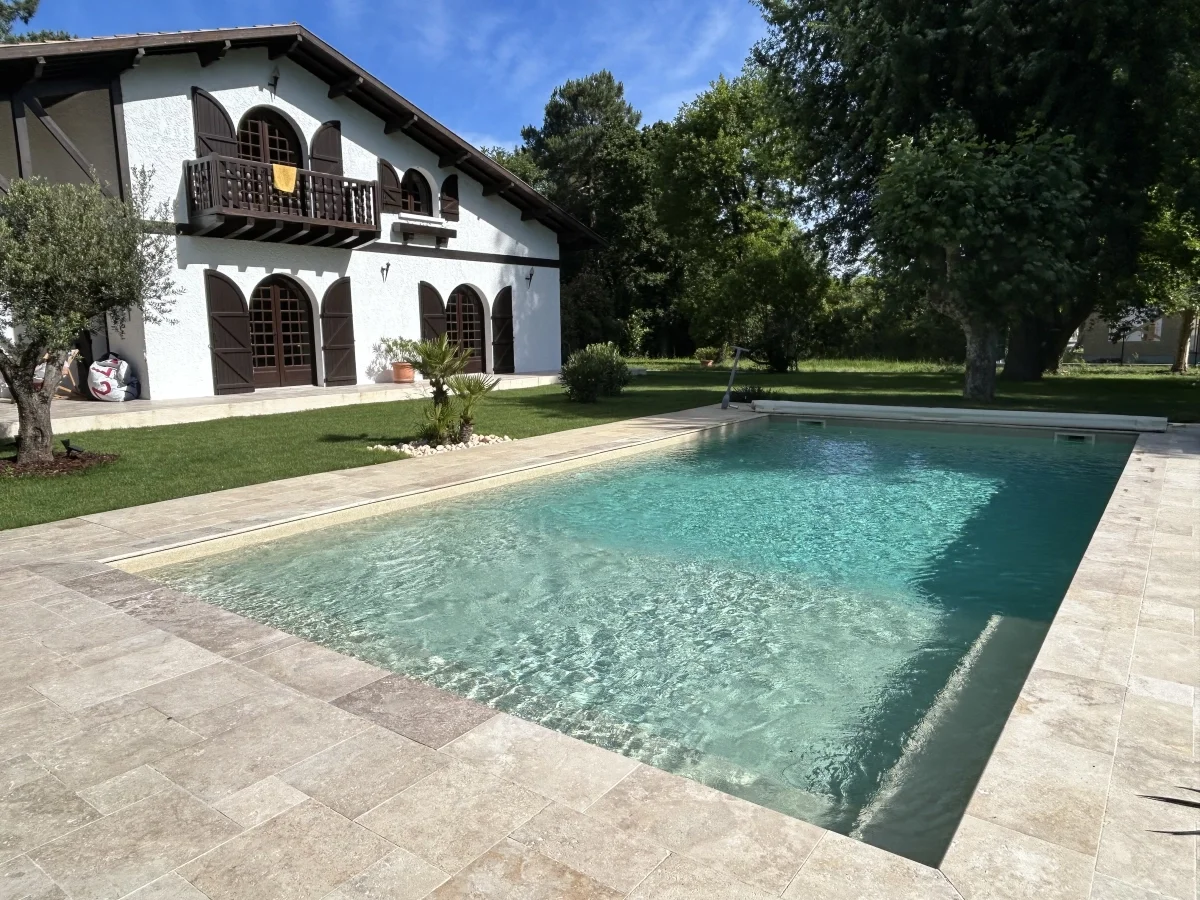 Piscine en béton entourée d’une terrasse en pierre